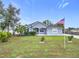 Charming single-story home features a well-manicured lawn and an American flag at 4649 Sw 103Rd Street Rd, Ocala, FL 34476