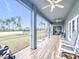 This spacious screened porch includes rocking chairs and ceiling fans at 4649 Sw 103Rd Street Rd, Ocala, FL 34476