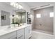 Modern bathroom with double vanity, a large mirror, and glass-enclosed walk-in shower with seating at 11018 Nellie Crossing Cir, Clermont, FL 34711