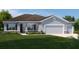 Charming single-story home featuring a three-car garage, stone accents, and a well-manicured lawn at 11018 Nellie Crossing Cir, Clermont, FL 34711