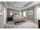 Elegant main bedroom with a tray ceiling, neutral decor, and a comfortable seating area at 11018 Nellie Crossing Cir, Clermont, FL 34711