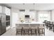 Bright kitchen with white cabinets, granite countertops, stainless steel appliances, a large island with seating, and modern fixtures at 11030 Nellie Crossing Cir, Clermont, FL 34711