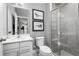 Bathroom featuring a sink, toilet, shower with glass doors, and two decorative wall hangings at 11054 Nellie Crossing Cir, Clermont, FL 34711
