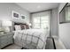 Bright bedroom featuring a window view, gray walls, with a patterned bed spread at 11054 Nellie Crossing Cir, Clermont, FL 34711