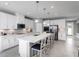 Modern kitchen boasts white cabinetry, stainless steel appliances, a spacious island, and pendant lighting for a contemporary feel at 11054 Nellie Crossing Cir, Clermont, FL 34711
