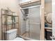Practical bathroom showcasing a glass-enclosed shower, toilet, and storage shelves for everyday essentials at 1711 Tierra Alta Dr, Lakeland, FL 33813