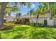 Charming single-story home with lush landscaping, a well-manicured lawn and mature trees in bright sunlight at 1711 Tierra Alta Dr, Lakeland, FL 33813