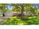 Charming single-story home with lush landscaping, a well-manicured lawn, mature trees and a large driveway at 1711 Tierra Alta Dr, Lakeland, FL 33813
