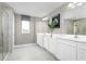Well-lit bathroom features double sinks, white cabinets, modern fixtures, and a glass-enclosed shower at 3034 Cayey Way, Clermont, FL 34711