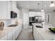 Well-lit kitchen with stainless steel appliances, quartz countertops, and sleek white cabinets at 3034 Cayey Way, Clermont, FL 34711