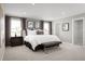 Spacious main bedroom features a king bed, bench, two windows, and an ensuite bath with walk-in closet at 3034 Cayey Way, Clermont, FL 34711