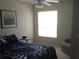 Cozy bedroom featuring a ceiling fan, large window, and comfortable bed at 3850 Plantation Blvd, Leesburg, FL 34748