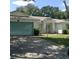 Charming single-story home features a two-car garage, light green door, and a well-maintained front yard at 3850 Plantation Blvd, Leesburg, FL 34748