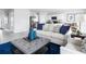 Cozy living room with a comfortable sofa, stylish blue accents, and an open view into the well-equipped kitchen at 416 Harvard Ct, Dundee, FL 33838