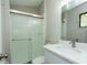 This bathroom features tile floors, a glass shower, white vanity, and ample lighting at 910 Nw 56Th Ave, Ocala, FL 34482