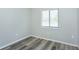 Serene bedroom showcasing gray wood-look flooring, a window for natural light, and neutral decor at 910 Nw 56Th Ave, Ocala, FL 34482