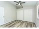 This bedroom features neutral paint, wood-look floors, a ceiling fan, and closets with sliding doors at 910 Nw 56Th Ave, Ocala, FL 34482
