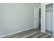 Cozy bedroom featuring gray wood-look flooring, a closet, and a view into the laundry room at 910 Nw 56Th Ave, Ocala, FL 34482