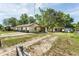 A single-story home with a simple design, complemented by a backyard shed and mature trees at 910 Nw 56Th Ave, Ocala, FL 34482