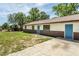 Charming single-story home with a metal roof, blue front door, and driveway at 910 Nw 56Th Ave, Ocala, FL 34482