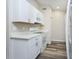 Well-lit kitchen features white cabinets, quartz countertops, a modern microwave, and gray wood-look floors at 910 Nw 56Th Ave, Ocala, FL 34482