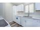 Bright kitchen featuring white cabinets, quartz countertops, a stainless-steel faucet, and modern appliances at 910 Nw 56Th Ave, Ocala, FL 34482
