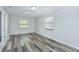Spacious living room with modern gray wood-look flooring, large windows, and ample natural light at 910 Nw 56Th Ave, Ocala, FL 34482
