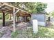 A weathered shed with a covered area, ideal for storage and offering a glimpse into the backyard at 910 Nw 56Th Ave, Ocala, FL 34482