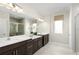 Spacious bathroom with double vanity, a large mirror, and glass-enclosed shower featuring updated fixtures at 9836 Pine Mill Ct, Clermont, FL 34711