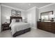 This bedroom features a large bed with decorative pillows, a dresser with mirror, and a side table with lamps at 9836 Pine Mill Ct, Clermont, FL 34711