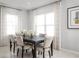 Bright dining room featuring neutral walls, modern lighting, and large windows with patterned drapes at 9836 Pine Mill Ct, Clermont, FL 34711