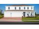 Two-story home with brick driveway, three-car garage, covered porch, and manicured lawn at 9836 Pine Mill Ct, Clermont, FL 34711