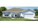 Charming single-story home with light blue exterior, stone accents, and a two-car garage at 9836 Pine Mill Ct, Clermont, FL 34711