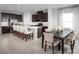 Open concept kitchen and dining area with stainless appliances, dark cabinets, quartz counters, and dining table at 9836 Pine Mill Ct, Clermont, FL 34711