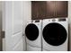 Well-equipped laundry room with modern washer and dryer units, along with overhead cabinetry for storage at 9836 Pine Mill Ct, Clermont, FL 34711