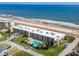 Aerial shot of a beachfront condo complex featuring a pool and scenic ocean views at 2600 Ocean Shore Blvd # 111, Ormond Beach, FL 32176