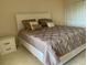 Bedroom with a bed featuring a brown comforter and white headboard, plus a nightstand at 2600 Ocean Shore Blvd # 111, Ormond Beach, FL 32176