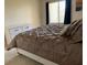 Cozy bedroom featuring a comfortable bed, dresser, and natural light from the window at 2600 Ocean Shore Blvd # 111, Ormond Beach, FL 32176