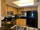 Kitchen featuring stainless steel appliances, and a black countertop with wooden cabinets at 2600 Ocean Shore Blvd # 111, Ormond Beach, FL 32176