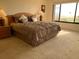 Bedroom featuring a queen bed, dresser, and bedside tables with lamps and ocean view at 2600 Ocean Shore Blvd # 111, Ormond Beach, FL 32176