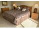 Bedroom featuring a queen bed, dresser, and bedside tables with lamps at 2600 Ocean Shore Blvd # 111, Ormond Beach, FL 32176