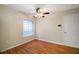 Bedroom with stylish flooring, bright window, ceiling fan, and convenient access to a door at 7355 Se 106Th Pl, Belleview, FL 34420