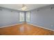 Spacious bedroom with hardwood floors, ceiling fan, and two windows with plantation shutters at 7355 Se 106Th Pl, Belleview, FL 34420