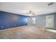 This bedroom features carpet floors, a ceiling fan, and a blue accent wall at 7355 Se 106Th Pl, Belleview, FL 34420