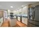 This kitchen features an island, stainless steel appliances, granite counters, and wood flooring at 7355 Se 106Th Pl, Belleview, FL 34420