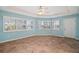 This living room features tile floors, a ceiling fan, and multiple windows with blinds at 7355 Se 106Th Pl, Belleview, FL 34420