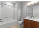 Bright bathroom features a tiled shower-tub combo, vanity with brown cabinets, and a neutral color scheme at 9262 Sw 102Nd Avenue Rd, Ocala, FL 34481