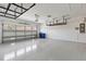 Spacious garage with epoxy flooring, overhead storage racks, and a white garage door at 9262 Sw 102Nd Avenue Rd, Ocala, FL 34481