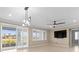 Open living room with tile flooring, modern light fixture and access to outdoor patio at 9262 Sw 102Nd Avenue Rd, Ocala, FL 34481