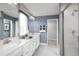 Well-lit bathroom features dual sinks, a sleek shower, and modern fixtures, perfect for a fresh start at 1310 Whispering Ln, Minneola, FL 34715